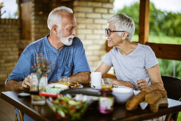 istock Happy mature couple talking while having breakfast on a balcony. 1345284621