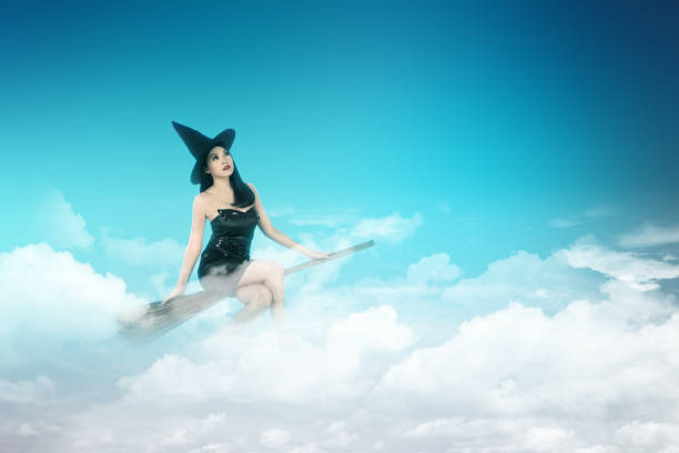 Asian witch woman with hat flying on a magic broomstick with cloudscapes on the sky
