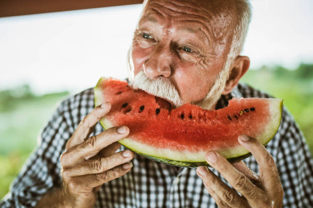 istock Smiling senior man enjoying in fresh watermelon. 1345284954