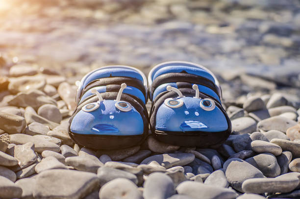 istock Blue summer flip-flops standing on the rocky shore 1345287401
