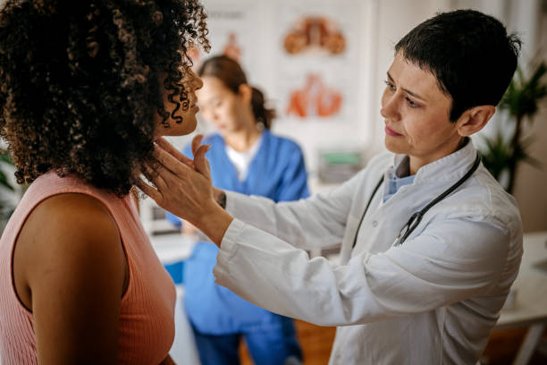 doctora que realiza un examen médico - touching neck fotografías e imágenes de stock