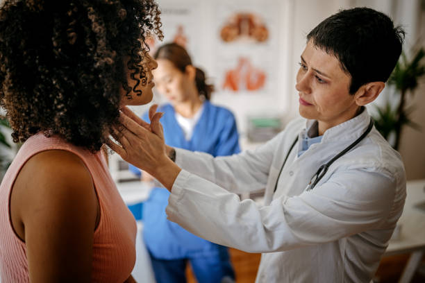 Female doctor doing a medical examination Female doctor examining a female patient in his medical office while female nurse writing information about patient prevention stock pictures, royalty-free photos & images