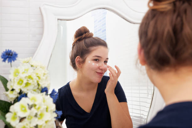 istock Woman applying moisturiser on face during morning routine 1345288590
