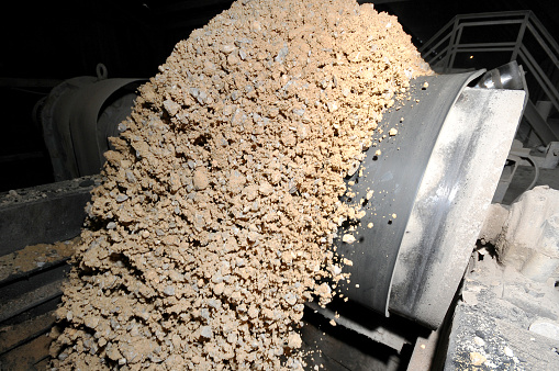 Many small crushed stones on the production line at the construction materials production factory, heavy industry concept