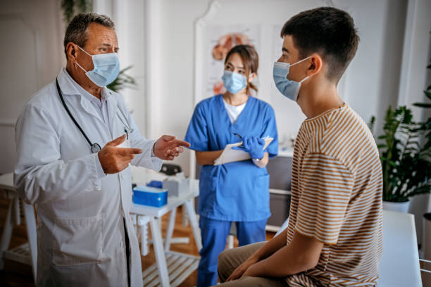 ragazzo adolescente con il suo medico preferito - doctor patient doctors office teenager foto e immagini stock