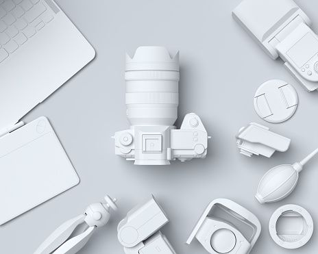 Top view of monochrome designer workspace and gear like laptop, tablet, digital camera and spidlight flash on black background. 3d rendering of accessories for illustrator and photography tools