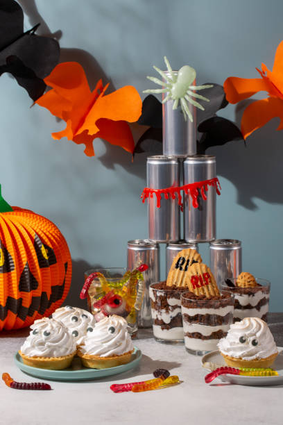istock Sweets for Halloween party. Halloween candy buffet. Graveyard trifle  dessert cups,  ghost meringue tarts and scary gummies in Halloween decorations. 1345290470