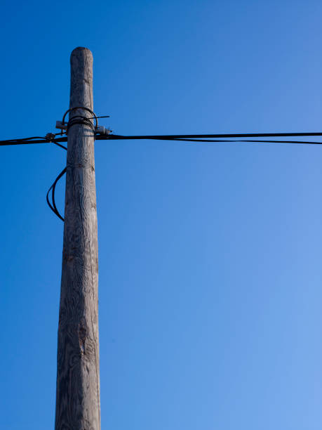 Wooden phone pole against a blue sky