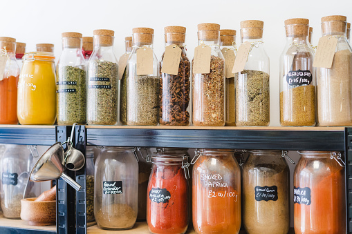 Eco-friendly zero waste shop. Glass bottles, jars with herbs and spices in sustainable plastic-free grocery store. Bio organic food. Shopping at small local businesses. New trend alternative buying.