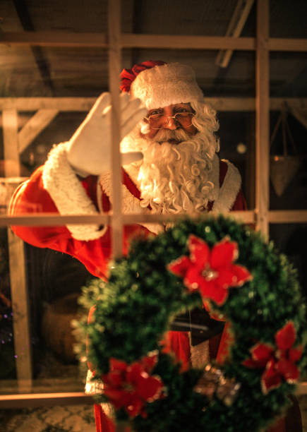 istock happy old Santa Claus using laptop and phone at home 1345292852