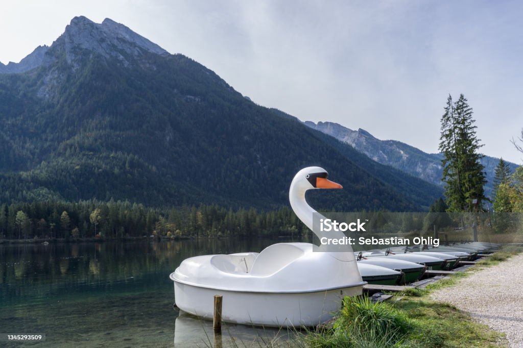 many rental boats at a bridge on lake in the mountains and a swan boat many rental boats at a bridge on lake in the mountains, swan boat Nautical Vessel Stock Photo