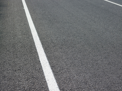 Asphalt road texture background, white guidelines on street