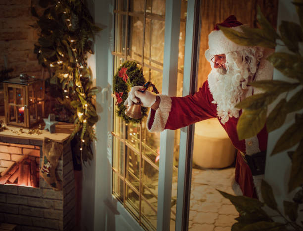 istock happy old Santa Claus using laptop and phone at home 1345294100