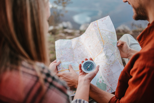 Couple of campers using compass and a map to explore an area