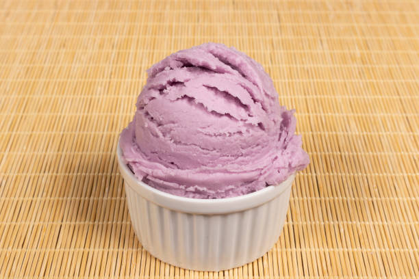 мерная ложка фиолетового мороженого со вкусом винограда подается в белой миске. крупный план гастрономической фотографии. - red grape grape fruit sweet food стоковые фото и изображения