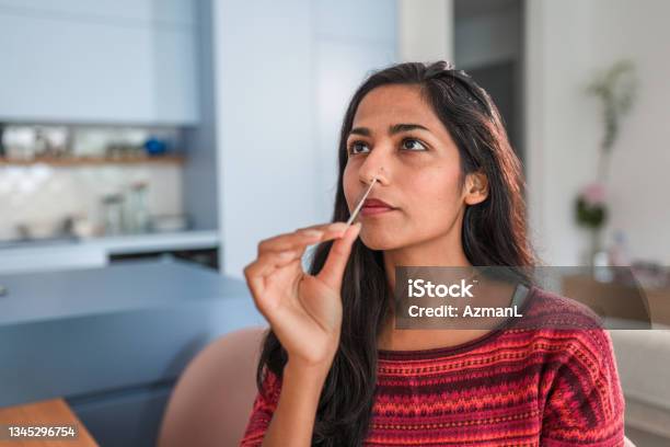 Close Up Of An Indian Young Woman Getting Taking A Covid Self Test In The Kitchen Stock Photo - Download Image Now