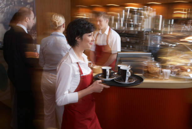 コーヒーショップでコーヒーカップとトレイを運ぶウェイトレス - serving tray ストックフォトと画像