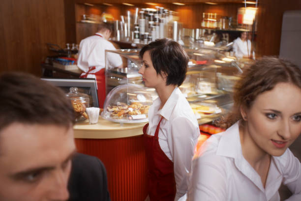 istock Customers and waitress in coffee shop 1345301737