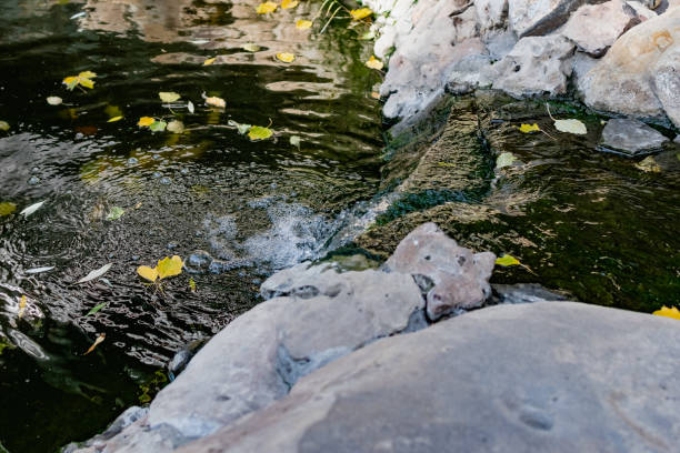 istock A beautiful artificial waterfall over a calm pond, decorated with interesting plants and unusual stones and decorations, a walk in the park in the fresh air 1345303051