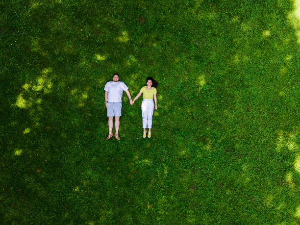istock smiling couple laying down on green grass 1345303614