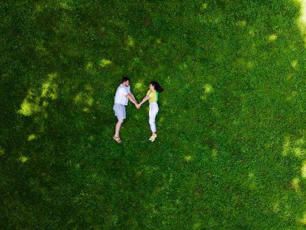 istock smiling couple laying down on green grass 1345303619