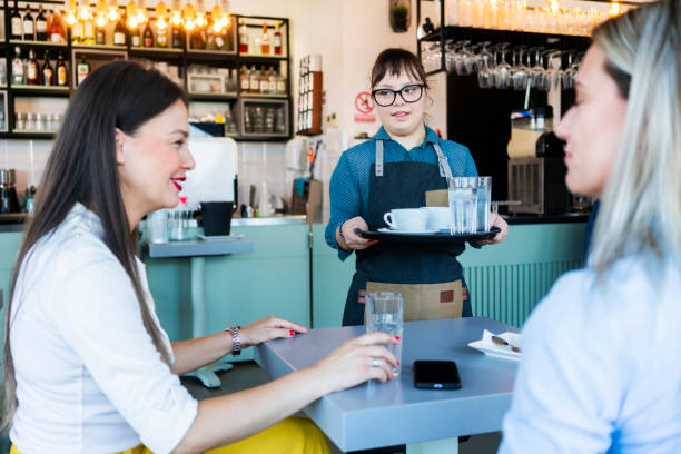 istock Young woman with Down Syndrome working at cafe 1345306055
