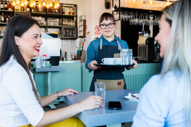 istock Young woman with Down Syndrome working at cafe 1345306089