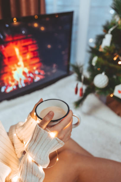 istock woman hands holding coffee mug near christmas tree 1345309506