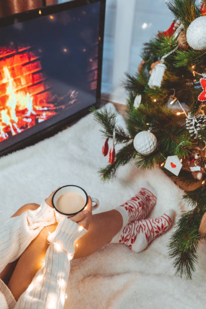 istock woman hands holding coffee mug near christmas tree 1345309508