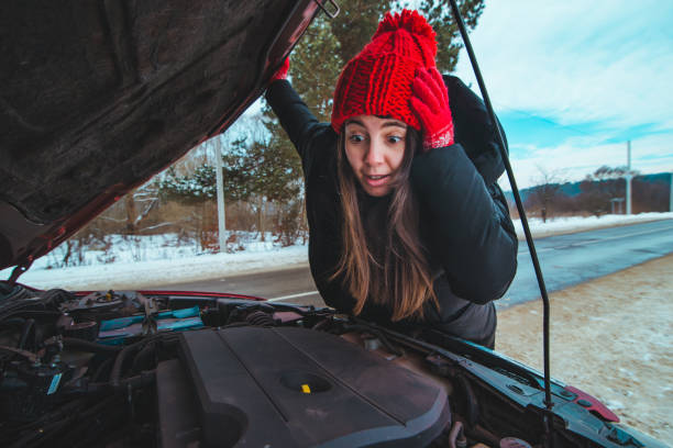 istock woman looking at car engine road assistance 1345309535