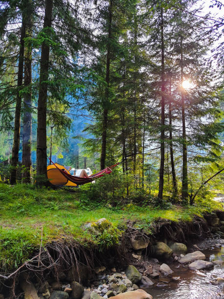 woman resting laying on hammock at camping site