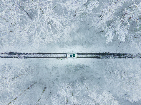 view of the white car from above in frozen winter forest copy space