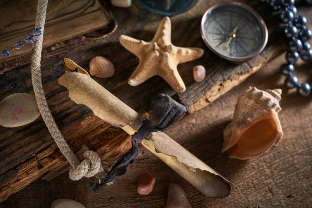 istock A marine concept with a bottle, starfish, seashells, rope, compass and paper scroll, pirate still life 1345310973