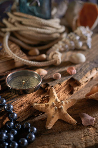 istock A marine concept with a bottle, starfish, seashells, rope, compass and paper scroll, pirate still life 1345310990