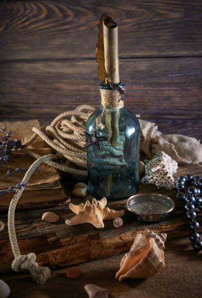 istock A marine concept with a bottle, starfish, seashells, rope, compass and paper scroll, pirate still life 1345310993
