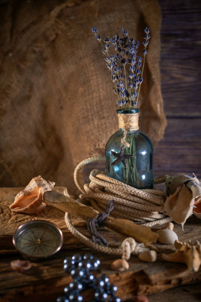 istock A marine concept with a bottle, starfish, seashells, rope, compass and paper scroll, pirate still life 1345311022