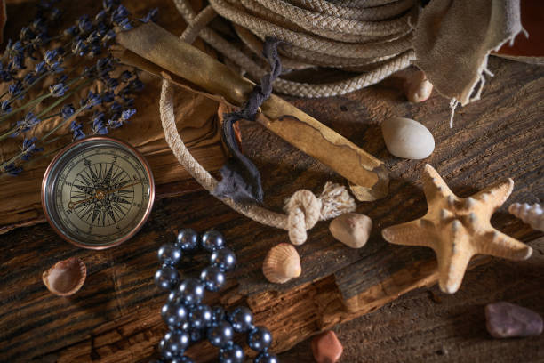 istock A marine concept with a bottle, starfish, seashells, rope, compass and paper scroll, pirate still life 1345311027