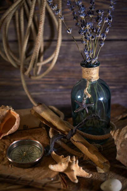 istock A marine concept with a bottle, starfish, seashells, rope, compass and paper scroll, pirate still life 1345311069