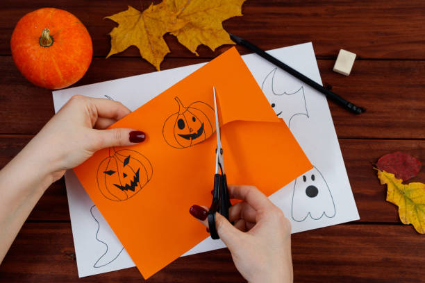 istock Halloween DIY. Cute pumpkins and paper ghosts. Step-by-step instruction. 1345312291