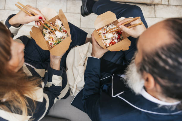 istock Business people taking a break and eating Poke with take out box 1345313368