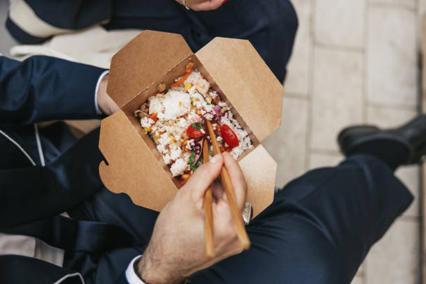 istock Businessman taking a break and eating Poke with take out box 1345313509
