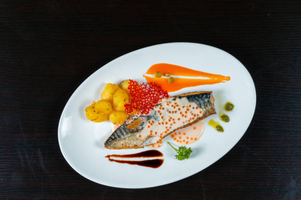 istock Grilled capelin with potatoes and different sauces on a black background 1345314989