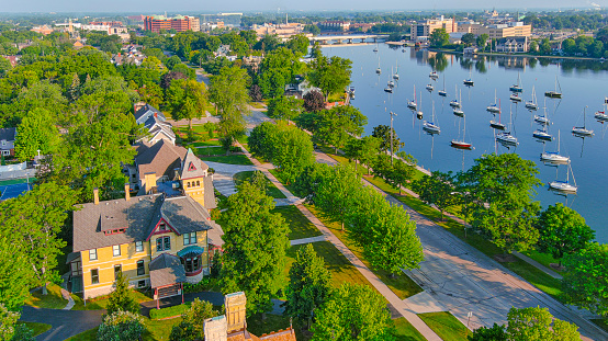 Many sailboats on river through historic neighborhood in Menasha Wisconsin, aerial view.