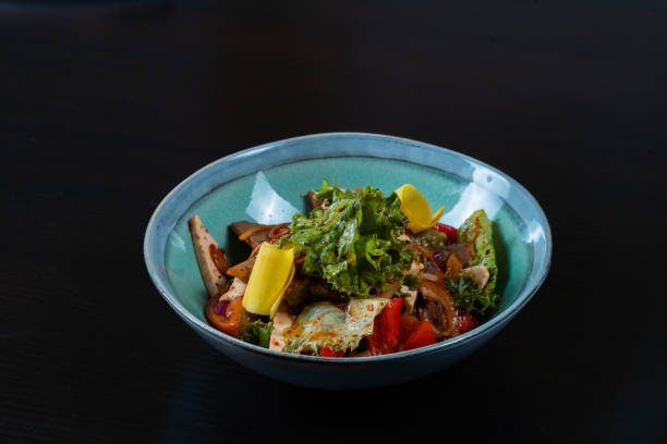 istock Salad with meat and vegetables on a black background 1345316919