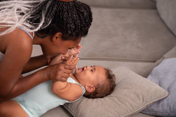 istock Mother with the baby on a grey couch. 1345319027