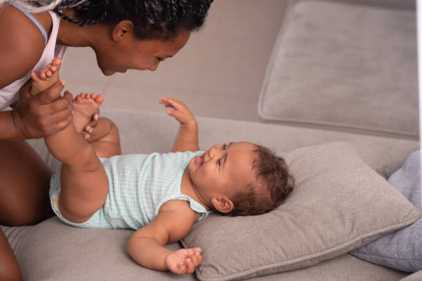istock Mother with the baby on a grey couch. 1345319223