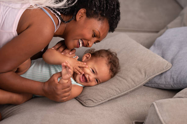 istock Mother with the baby on a grey couch. 1345319230