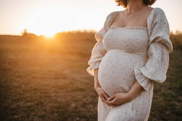 istock Pregnant woman at sunset 1345319530