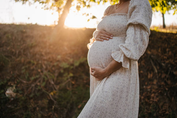 istock Pregnant woman at sunset 1345320225