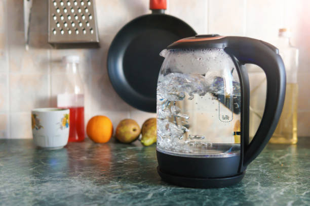 istock Electric transparent glass teapot boils in the kitchen 1345321862